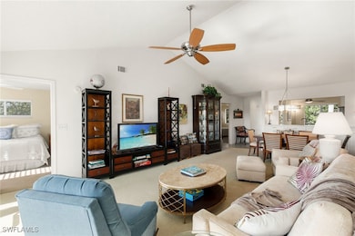 Carpeted living room with a ceiling fan, plenty of natural light, and high vaulted ceiling