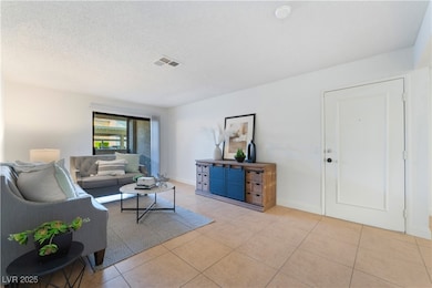 Tiled living area with a textured ceiling, visible
