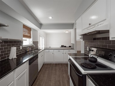 Kitchen featuring dishwasher, dark hardwood / wood