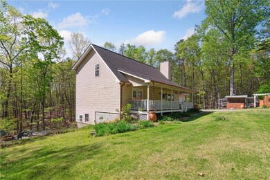View of side of home with a chimney, a yard, a porch, and roof with shingles