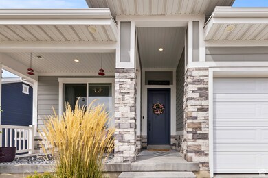 Doorway to property featuring stone siding and a garage