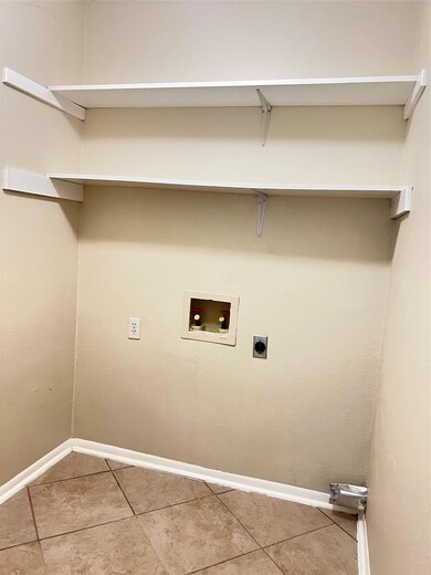 Laundry room with electric dryer hookup, light ti