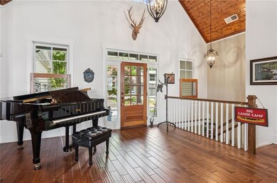 Entryway with high vaulted ceiling, a chandelier, wood finished floors, and wood ceiling