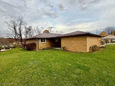 Rear view of property featuring a lawn and a patio