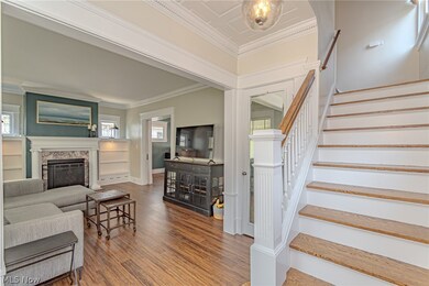 Living room featuring ornamental molding, a fireplace, and wood-type flooring