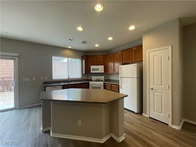 Kitchen with a sink, white appliances, wood finish