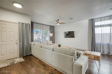 Living area featuring ceiling fan and dark wood-st