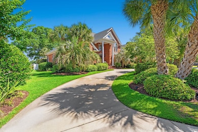 View of front of home featuring a front yard, brick siding, and concrete driveway