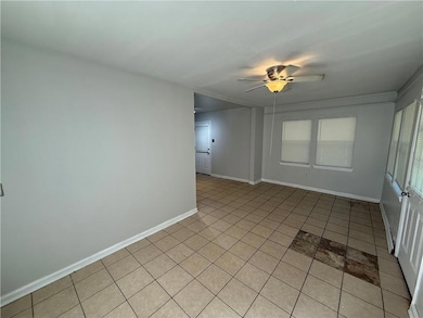 Spare room with light tile patterned floors and a ceiling fan