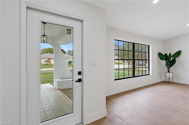 Entryway with baseboards, recessed lighting, and wood finished floors