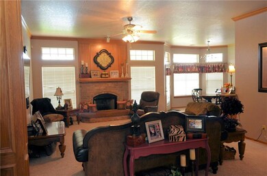 Living room with fireplace and gas logs open to ki
