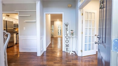 Hall with dark wood-style flooring and a decorative wall