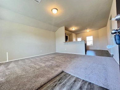 Unfurnished living room featuring dark wood finished floors and dark carpet