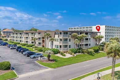 View of apartment building / complex with uncovered parking