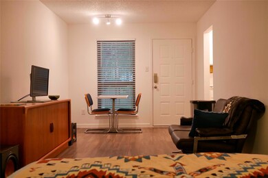 Bedroom with wood finished floors, baseboards, an