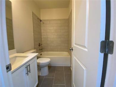 Guest bathroom has tiled shower walls and floors
