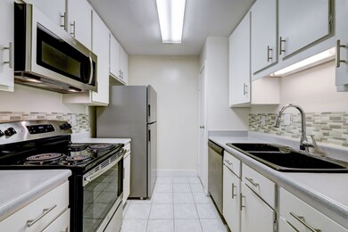 Nice size kitchen with white cabinets and brushed