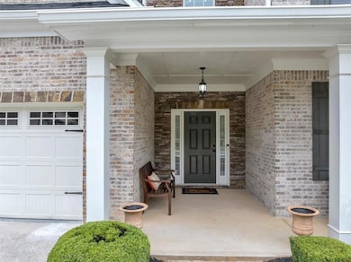 Property entrance featuring covered porch, brick s