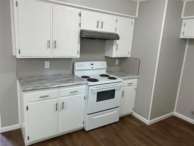Kitchen featuring white cabinets, dark hardwood / wood-style flooring, tasteful backsplash, and electric stove
