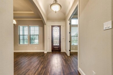 Foyer featuring crown molding, baseboards, and dark wood finished floors