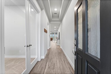 Entry way with office to the left and tiered ceili