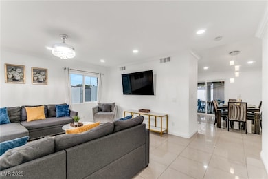 Living area with crown molding, light tile patterned floors, and recessed lighting