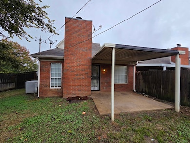 Rear view of property featuring a fenced backyard, a patio area, brick siding, and a chimney