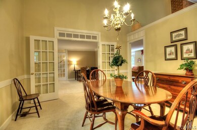 Elegant formal dining room has French doors, a cha