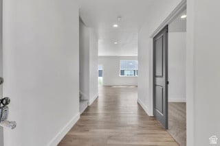 Hall featuring light wood-type flooring and recessed lighting