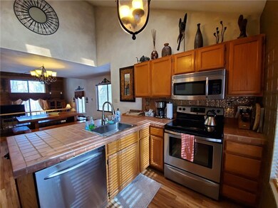 Stainless kitchen package fridge is on other wall.