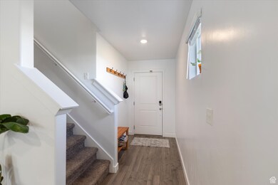 Entryway with dark wood-style floors, stairs, and recessed lighting