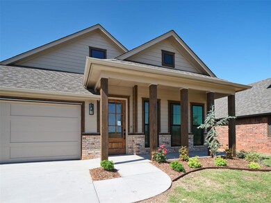 View of front of home with a shingled roof, a garage, a porch, and concrete driveway