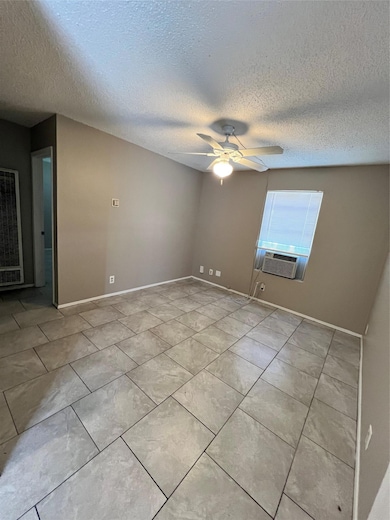 Empty room with baseboards, cooling unit, ceiling