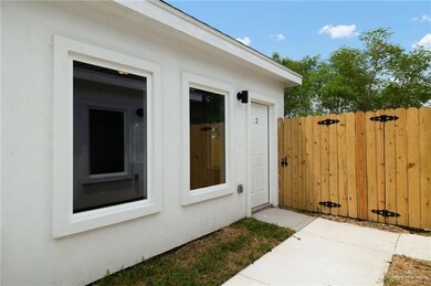 View of exterior entry featuring a gate and stucco siding