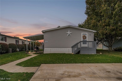 Manufactured / mobile home featuring a lawn and a wooden deck