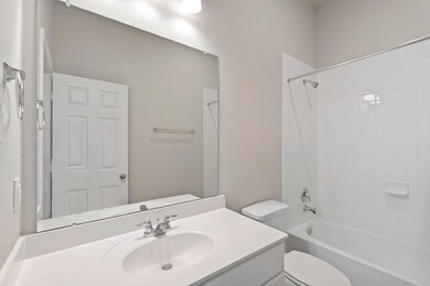 The secondary bath features tile flooring, white c