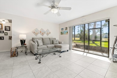 Living area featuring light tile patterned floors and ceiling fan
