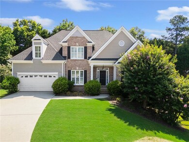 View of front of home featuring brick siding, a front yard, concrete driveway, a shingled roof, and a garage