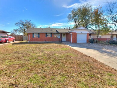 Single story home with a garage and a front lawn