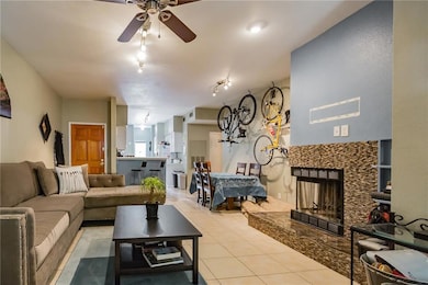 Living area with a ceiling fan, a fireplace, and 