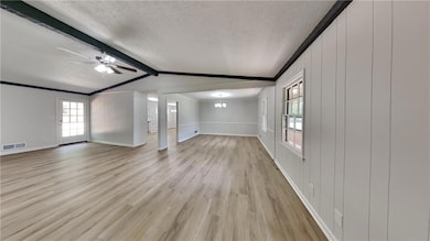 Unfurnished living room featuring a textured ceili