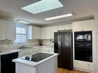 Kitchen featuring white cabinets, light hardwood /