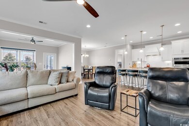 Living room with ceiling fan with notable chandeli