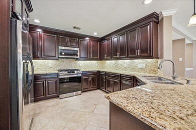 The beautifully updated kitchen features a combination of natural stone materials, rich cabinetry and stainless appliances including a gas range.