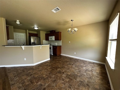 Kitchen with a chandelier, a kitchen bar, a penin