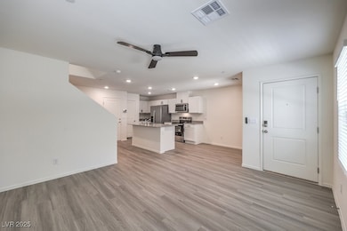 Unfurnished living room featuring a ceiling fan, l