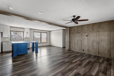 Unfurnished living room featuring dark wood-type 