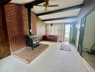 View to entry door and freestanding wood stove