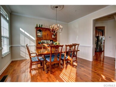 Formal dining room with chandelier, hardwood floor