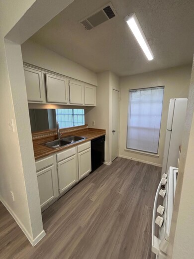 Kitchen featuring dishwashing machine, a sink, st